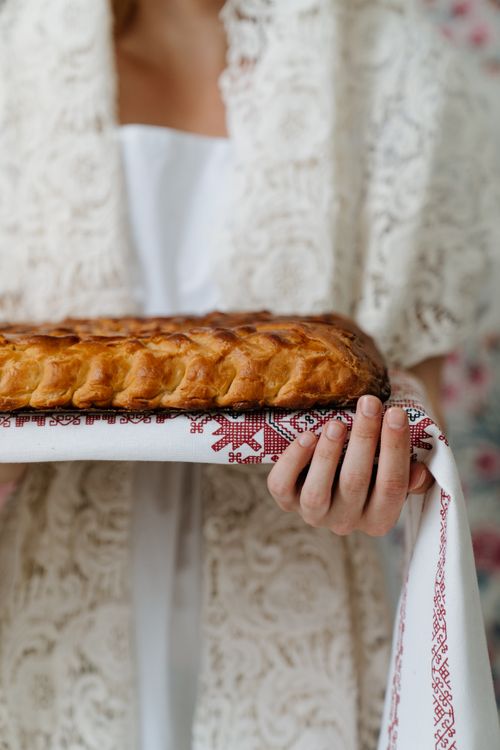 Free A rustic loaf of Russian bread on a traditional embroidered cloth, symbolizing cultural hospitality. Stock Photo