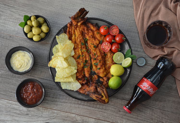 Tasty Fried Fish And Crispy Chips With Salsas And Coke