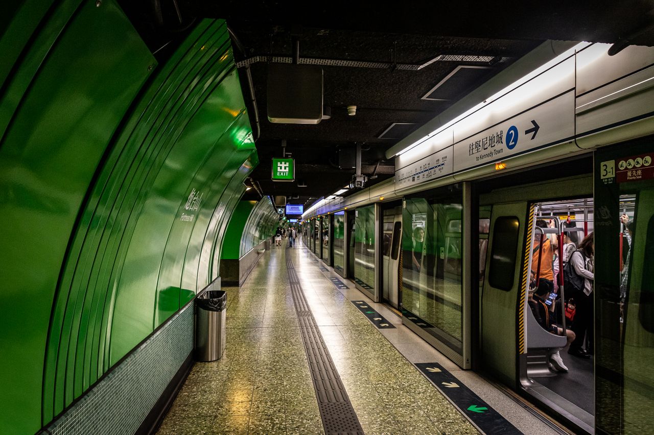 Sleek and vibrant Hong Kong subway station with passengers boarding the train.