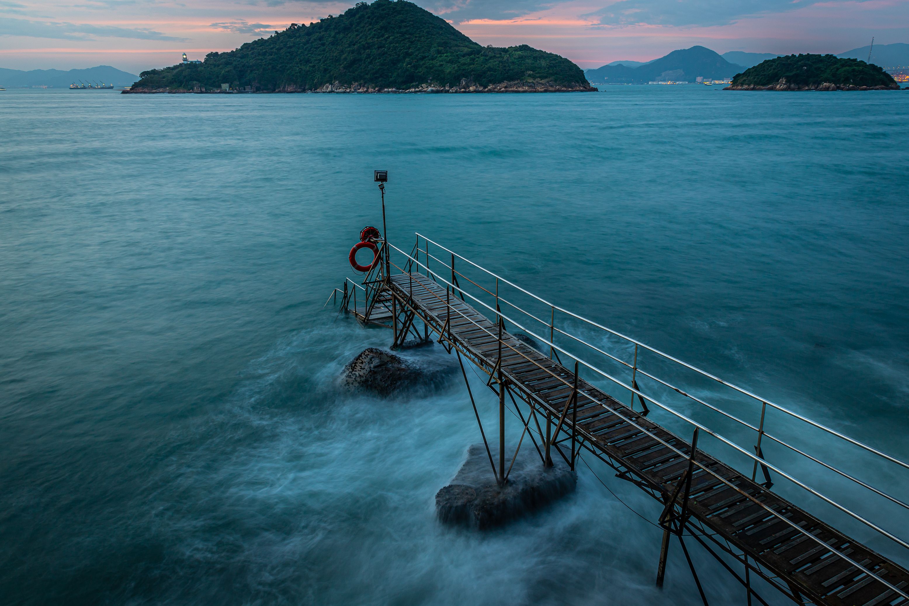 Stunning view of a serene pier and islands in Hong Kong during twilight, capturing natural beauty.