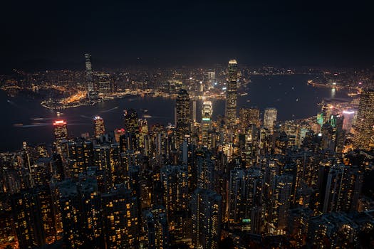 Experience the dazzling skyline of Hong Kong at night with glowing skyscrapers under the starry sky.