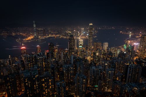 Free Experience the dazzling skyline of Hong Kong at night with glowing skyscrapers under the starry sky. Stock Photo