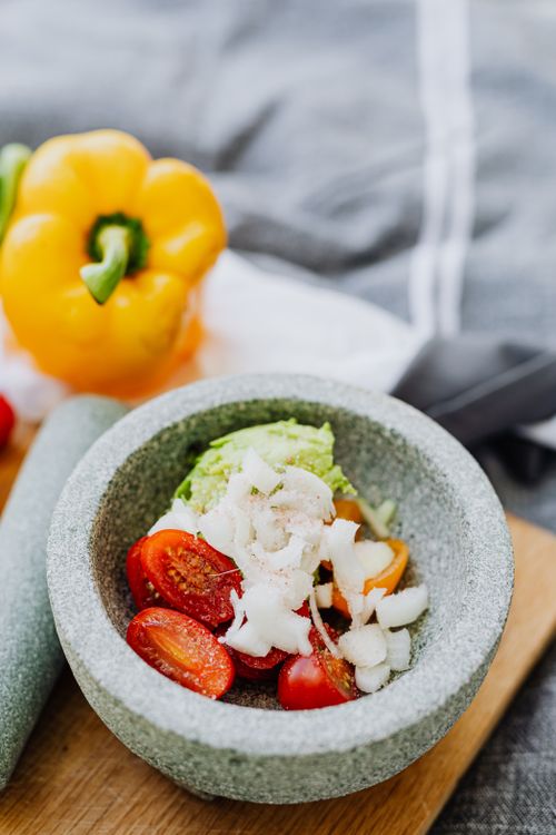 Free Colorful display of fresh vegetables in a mortar, ideal for making guacamole. Stock Photo