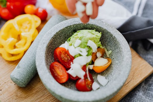 A vibrant close-up of fresh guacamole ingredients in a mortar for a healthy dish.