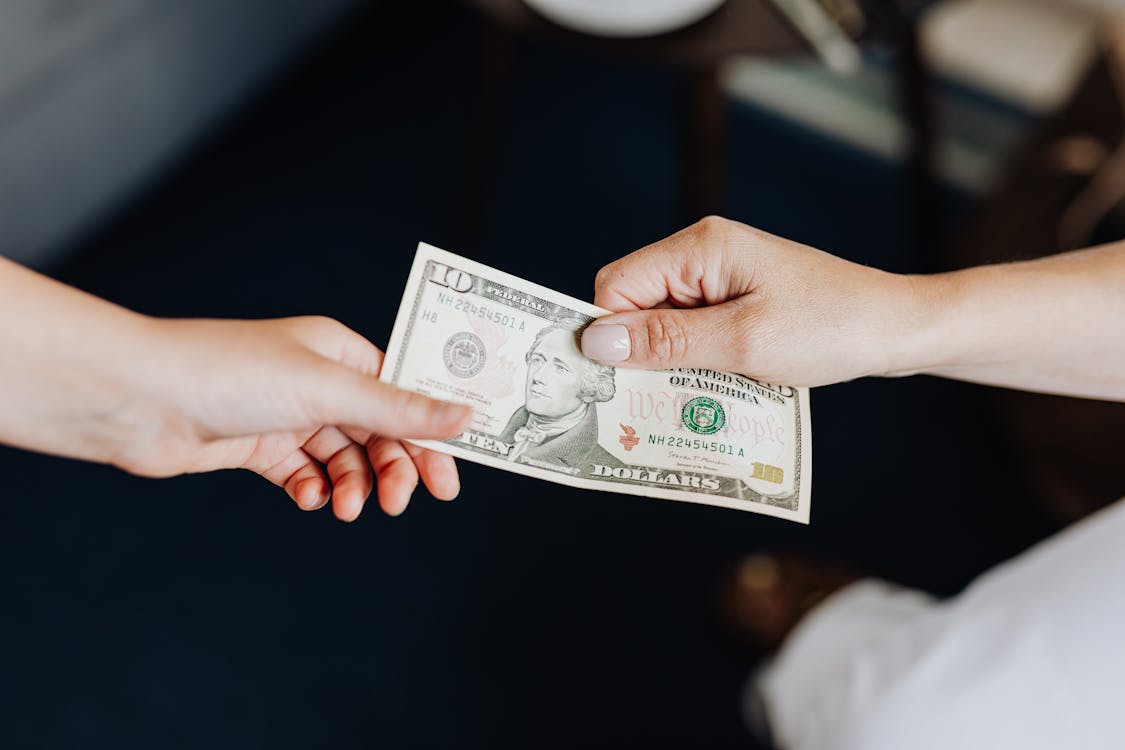 Free Hands Holding a 10 Dollar Bill Stock Photo