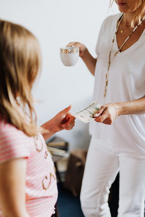 Free Mother Giving Her Daughter Her Allowance Stock Photo