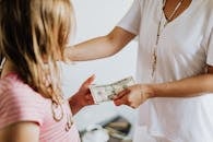 Woman Giving 10 Dollars to a Girl