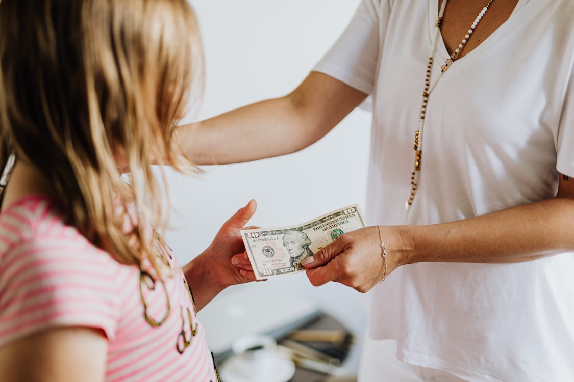 Free Woman Giving 10 Dollars to a Girl Stock Photo