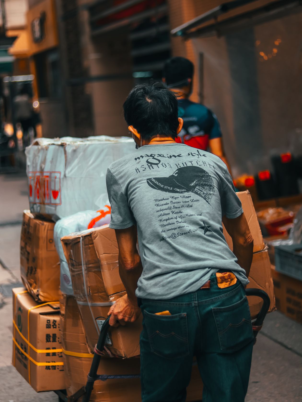 Warehouse worker pushing a trolley stacked with cartons