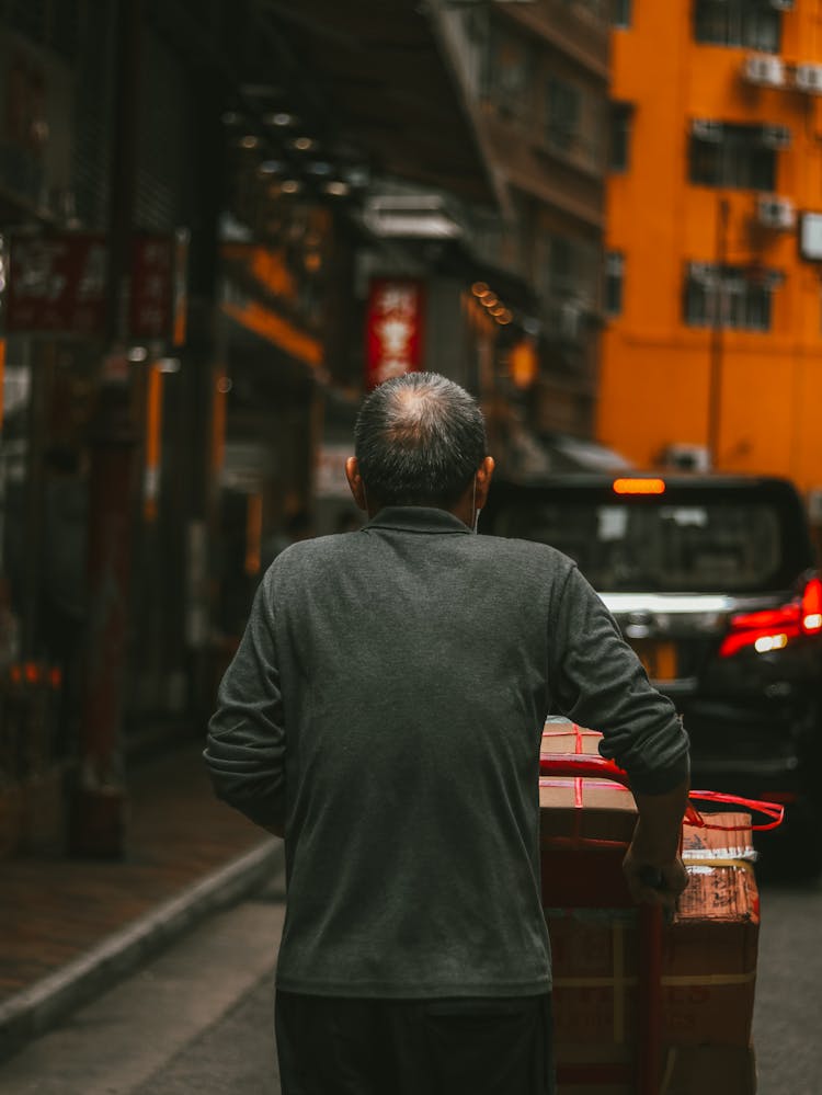 Unrecognizable Delivery Man Carrying Cardboard Boxes Placed On Cart