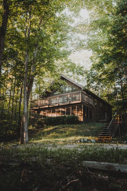 A cozy wooden cabin nestled among lush trees, perfect for a summer retreat.