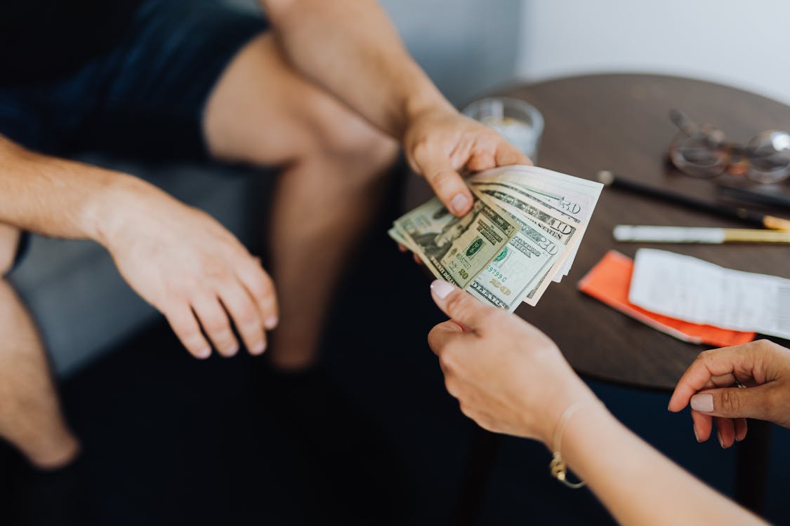 Free Person Giving Money to Another Person Stock Photo