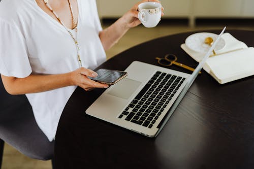 Woman Using Smartphone and Laptop