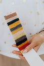 Woman Holding a Piece of Cardboard with Different Colored Threads 
