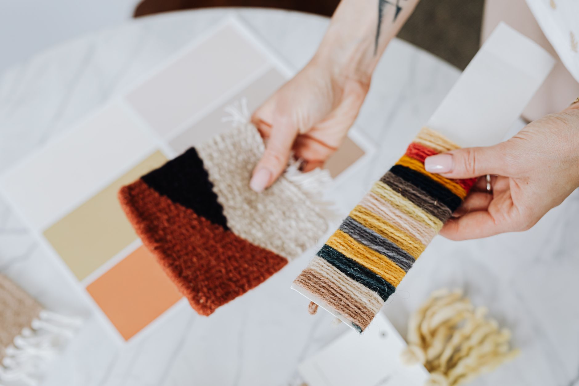 極簡風窗簾怎麼選?避開廉價感布料顏色尺寸全攻略 Hands holding fabric and thread samples for interior design inspiration.