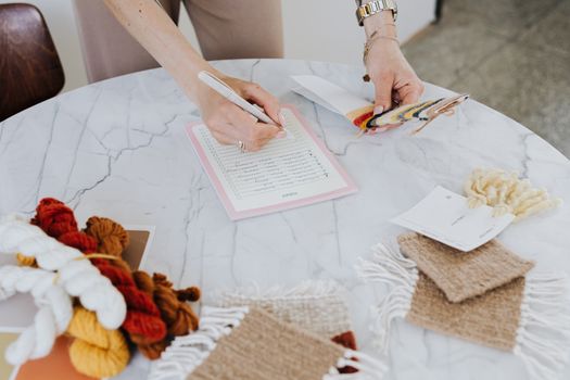 person taking notes on design swatches