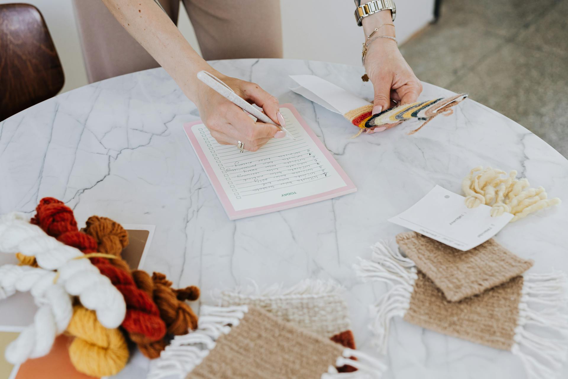 Close Up of Hands Working with Documents and Wool Samples