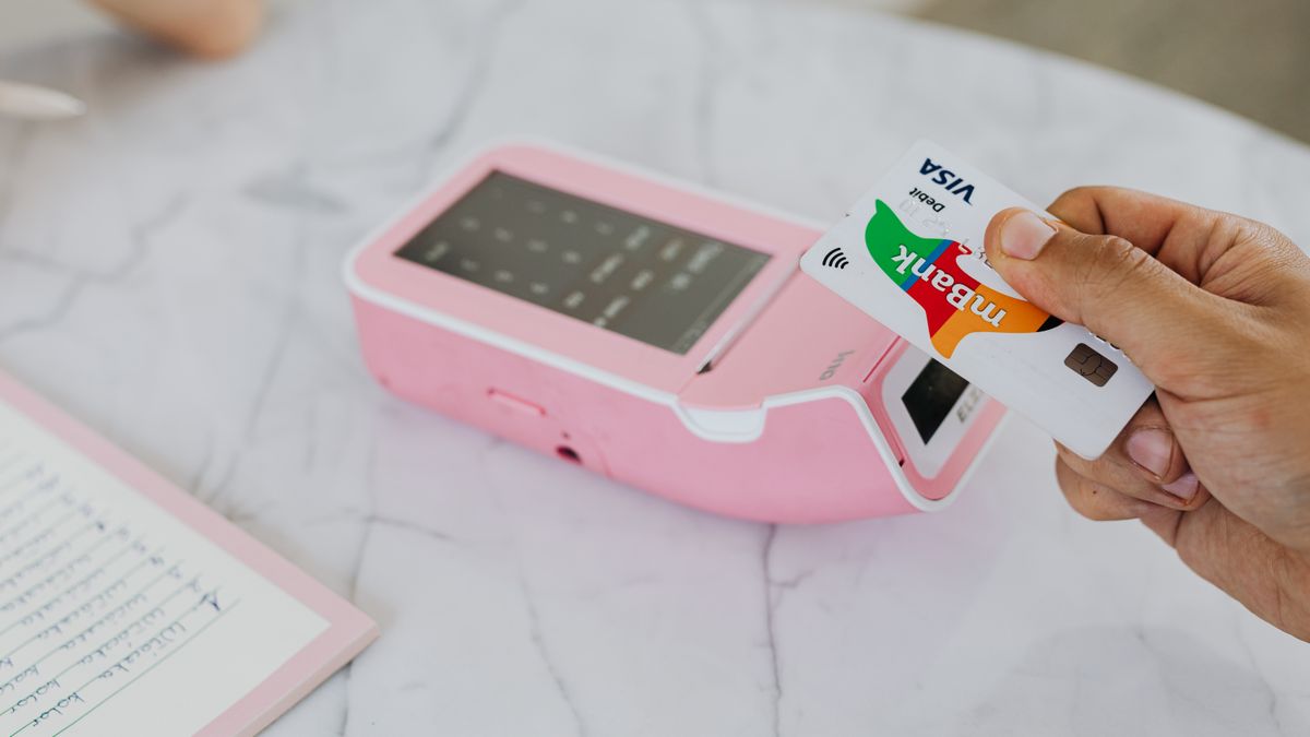 Contactless debit card being used to pay with a smartphone