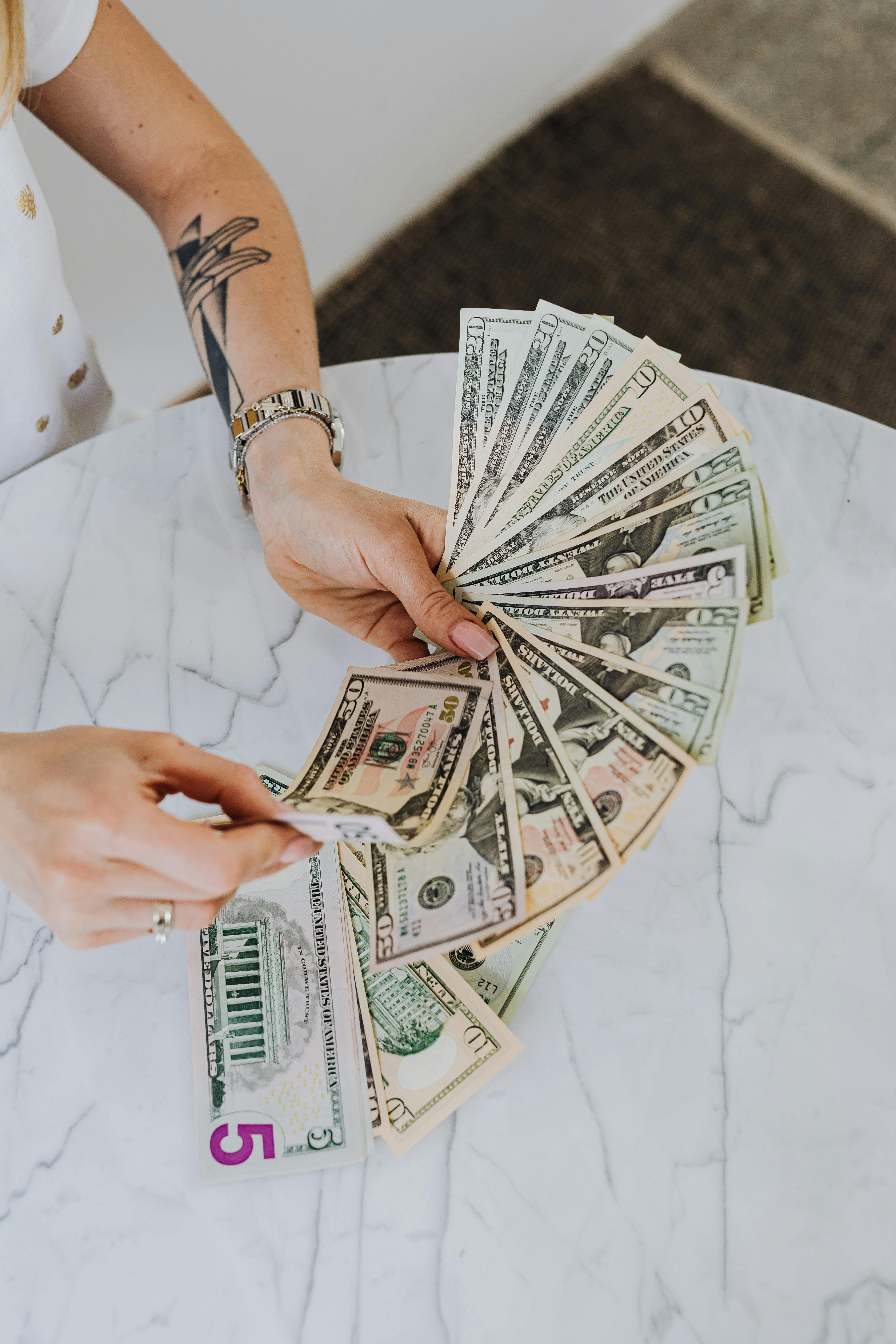 person holding fan of us dollar bills