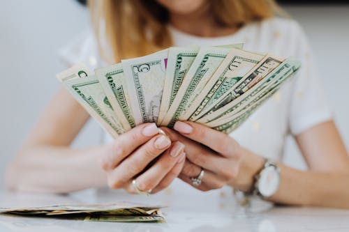 Woman Holding Fan of Dollar Bills