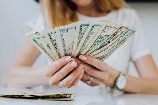 Close-up of a woman counting US dollar bills, symbolizing financial success and wealth management.