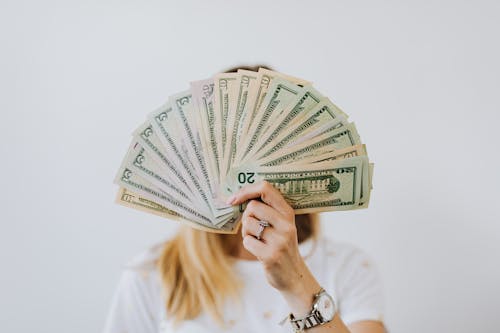 Woman Holding Fan of US Dollar Bills