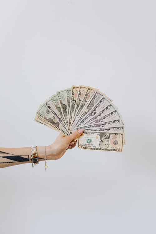 Woman Holding Fan of US Dollar Bills · Free Stock Photo