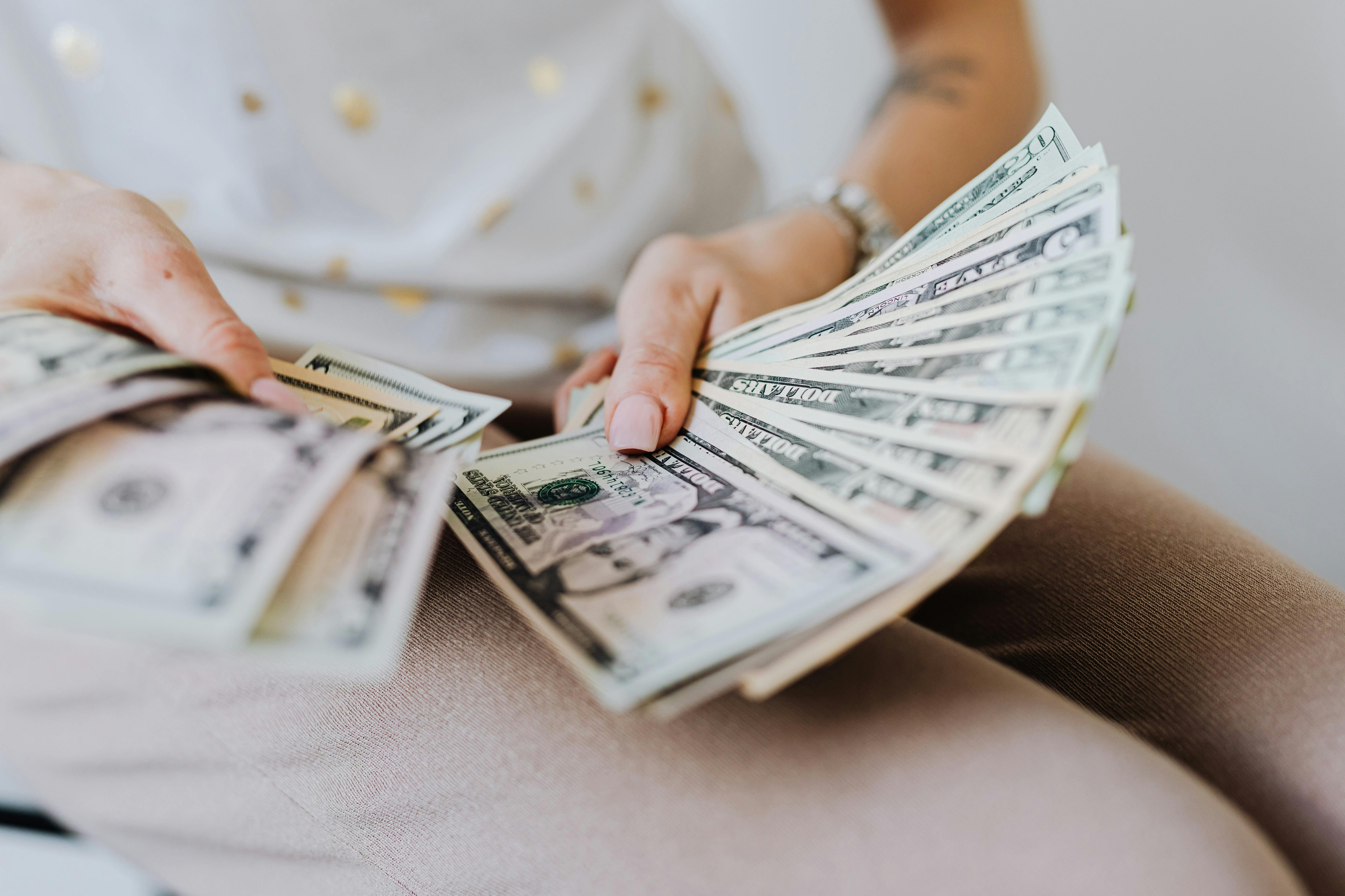 person holding fan of us dollar bills