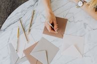 Person Holding Brown Paper on White Table