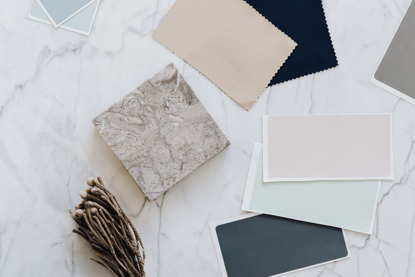 Fabric and material swatches laid out on a pale stone surface — Kaboompics.com on Pexels