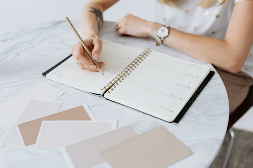 Free Person Writing on a Planner Stock Photo