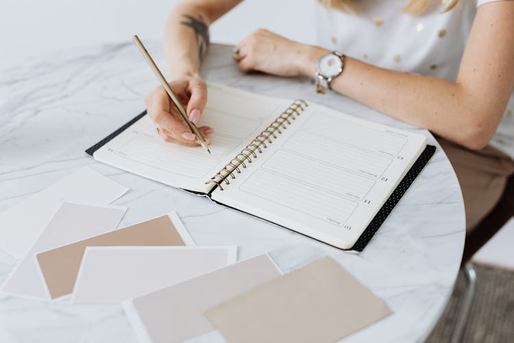 Person Writing On A Planner