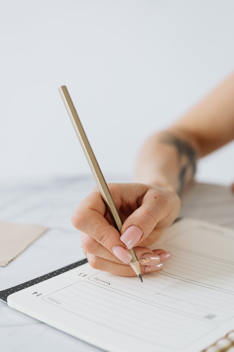 Womans Hand With Long Nails Holding A Pencil