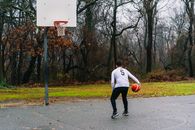Man in White Shirt and Black Pants Playing Basketball