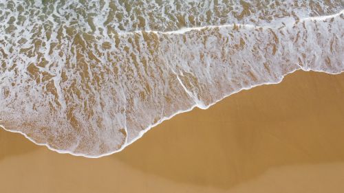 Free Drone shot capturing the foamy waves on Woonona Beach, NSW, Australia. Stock Photo