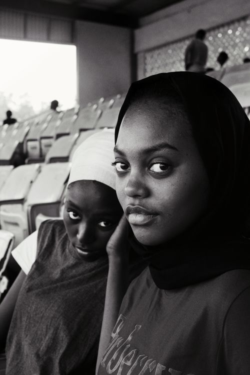 Free Intimate black and white portrait of two women sitting in a stadium, showcasing emotion and style. Stock Photo