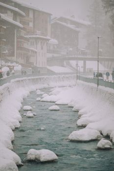 一条被雪包围的城市河流，冬季景色宁静