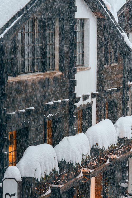 Facade of contemporary apartment building covered with thick layer of snow during intense snowstorm on freezing winter day