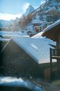 Picturesque scenery of small remote village cottages with snow on roofs located on frozen hilly terrain on sunny winter weather