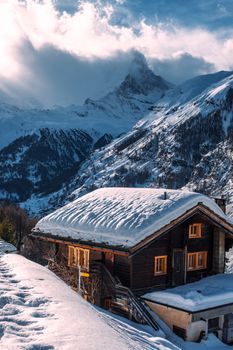 宁静的高山冬季场景中，坐落着一座迷人的白雪覆盖的小屋