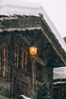 暴风雪中，一间舒适的木制小屋里，亮着一盏灯笼