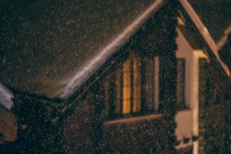 Snowy Wooden House During Snowfall At Night