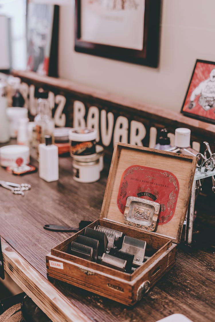 Vintage Box With Electric Razor Attachments Placed On Table In Barbershop