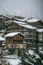 阿尔卑斯山村庄被大片雪山环绕，雾天里可见住宅和建筑