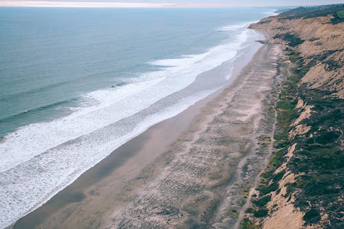 Пляжный берег с океанскими волнами, разбивающимися о берег