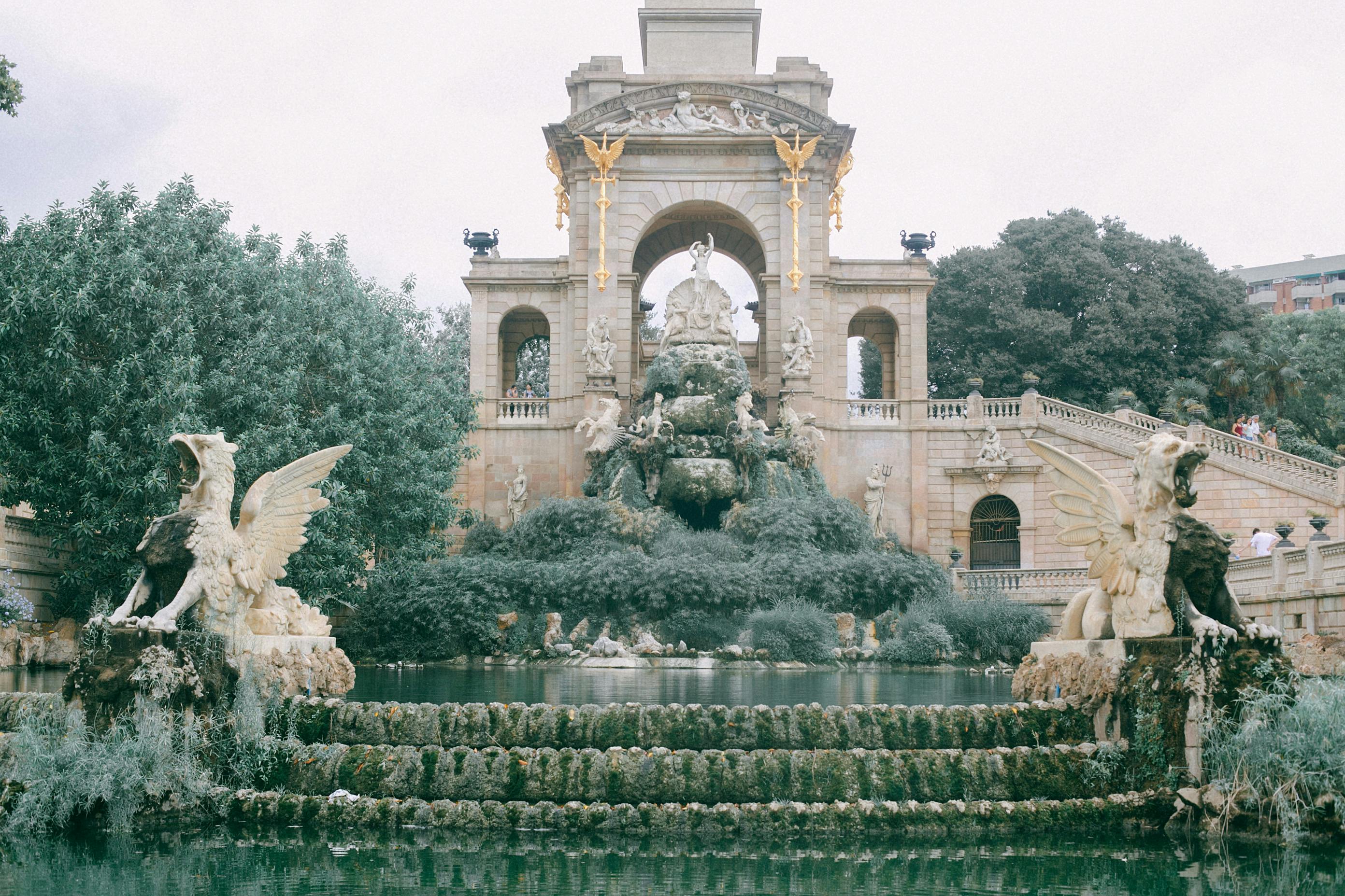 old stone monument with statues and fountain in garden