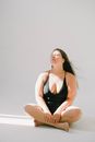 Woman in a Black Swimsuit Sitting with Her Eyes Closed