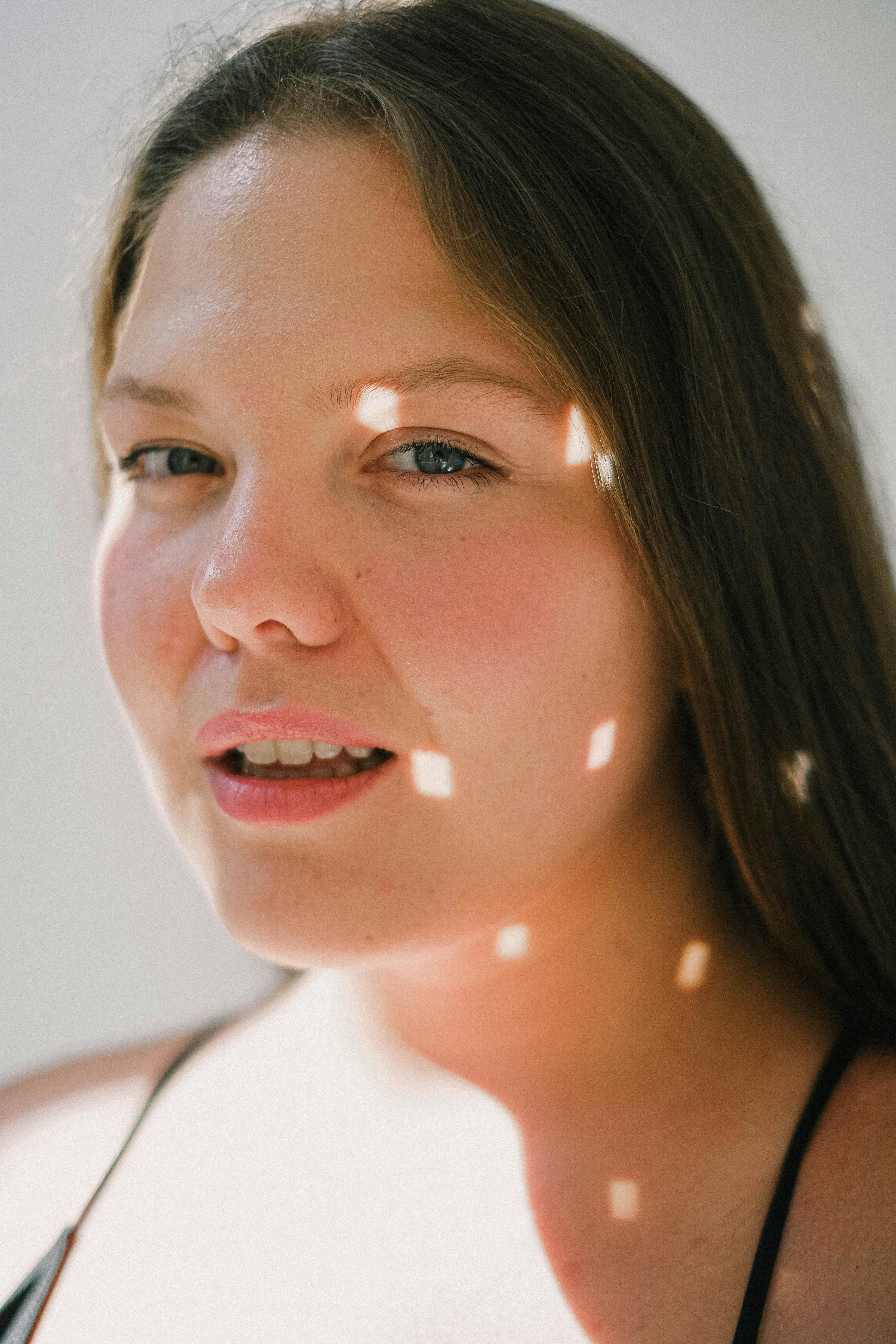 Close-up portrait of a woman in natural light indoors.