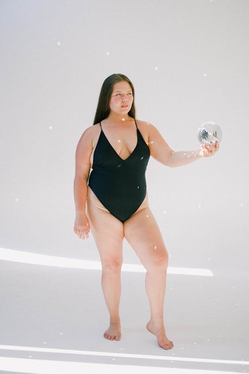 Woman in Black Swimsuit Holding Disco Ball
