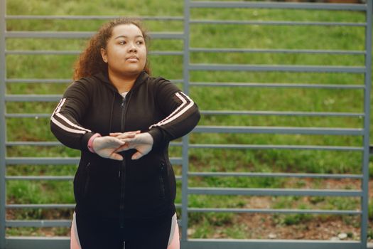 A young woman exercises outdoors in a park, embracing fitness and wellness.
